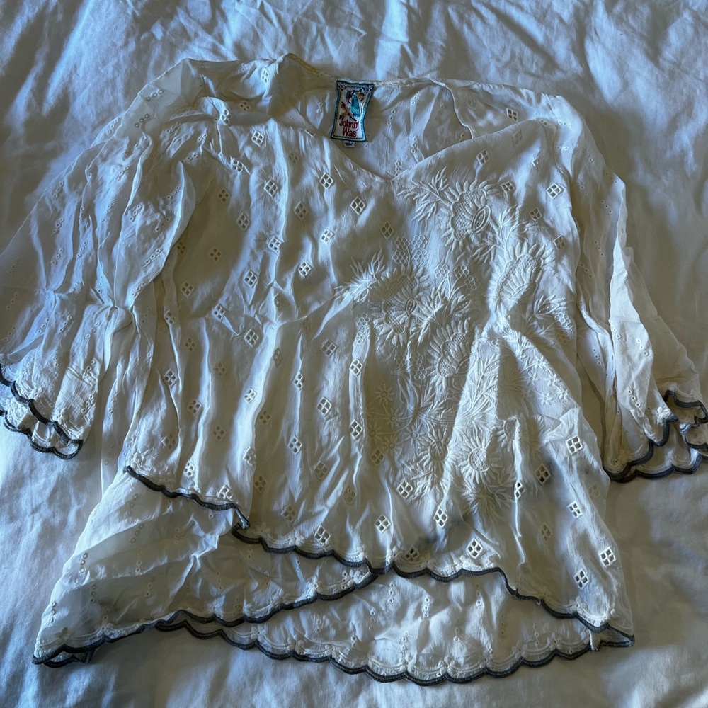 Johnny was white tunic blouse with gray embroidery and eyelit detail